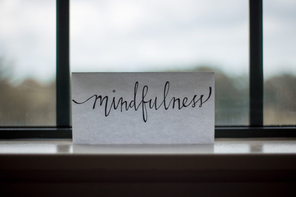 Paper sign on a window reading "mindfulness"