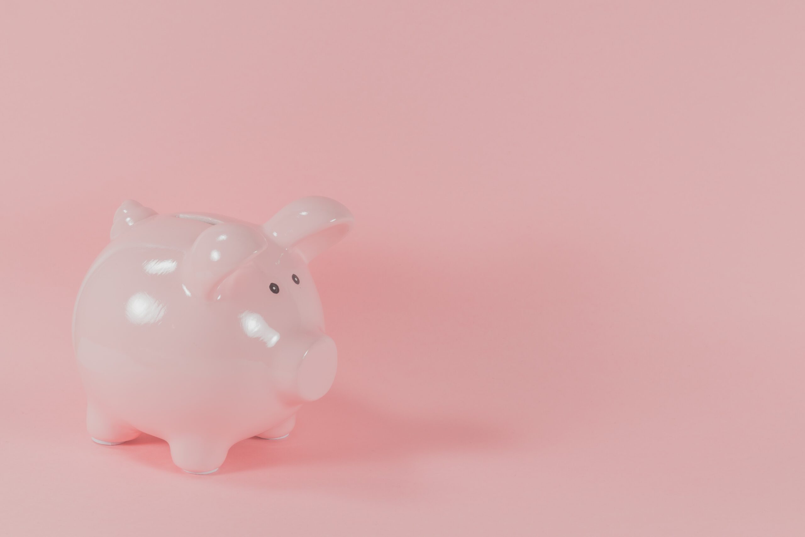 Pink piggy bank against a pink background